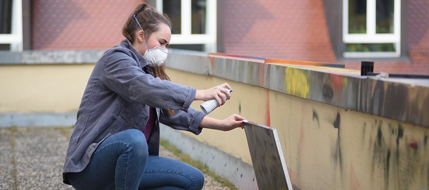 Schülerin macht Graffiti