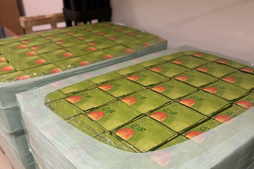 Zwei Paletten mit fertig abgefülltem Apfelsaft. Die Äpfel wurden bei der jährlichen Apfelernte selbst geerntet.