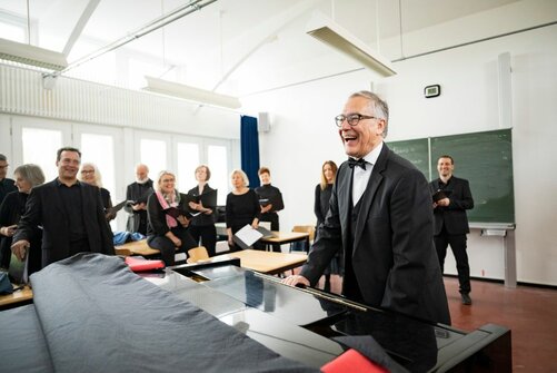 Thomas Braun am Klavier in einem Klassenzimmer auf dem Campus Härlen