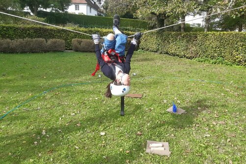 Teambuilding-Tag Jahrgangsstufe 6: Mädchen hängt kopfüber an einem Seil