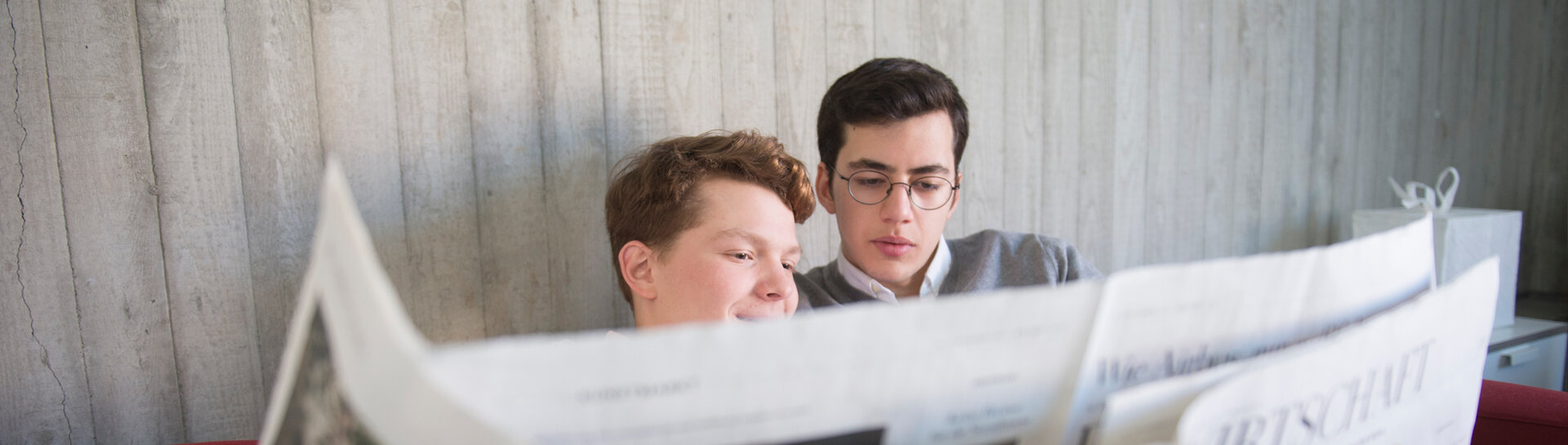 Headerbild: Zwei Jungen lesen Zeitung 