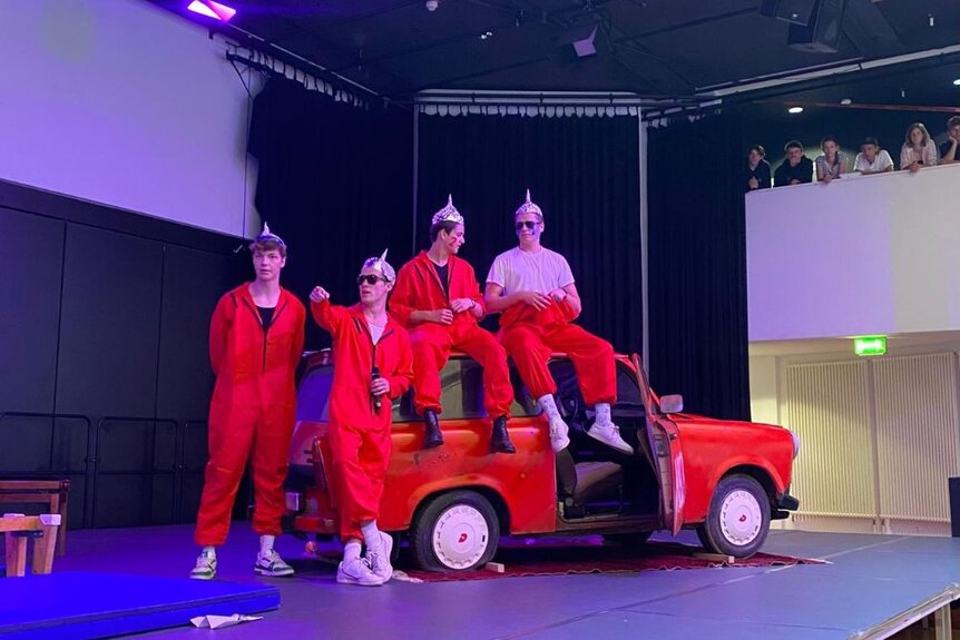 Schüler präsentieren Trabbi Honni auf der Bühne bei der Examensfeier 2024.