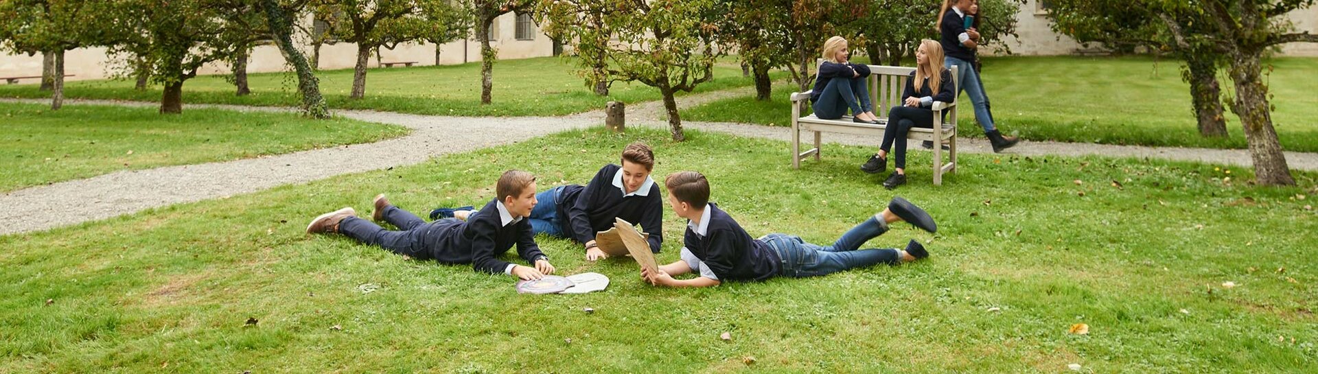 Drei Jungen liegen auf der Wiese im Innenhof von Schloss Salem