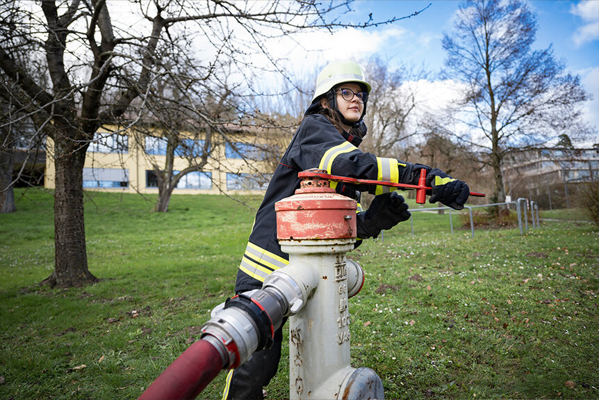 Schülerin des Feuerwehr-Dienstes lässt Wasser laufen