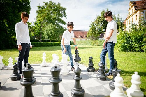 Jungs spielen vor dem Rentamt Schach.