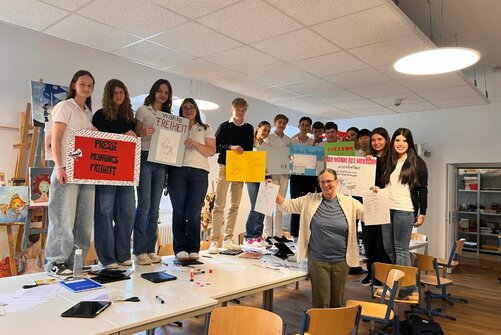 Kinder halten Plakate für die Demokratie hoch