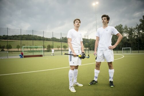 Schüler nach dem Hockeyspiel auf dem Spielfeld 